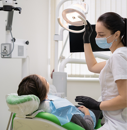 Dental team member talking to a patient in the treatment chair