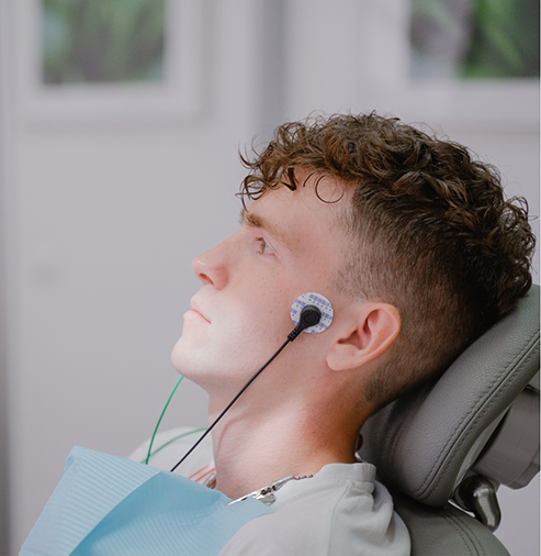 Young man with an electrode on either side of his jaws