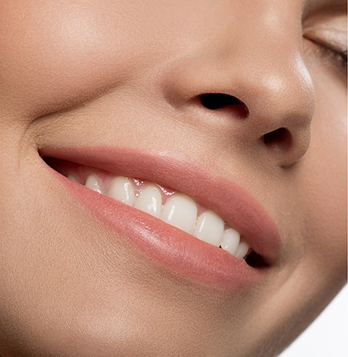 Close up of a person with straight white teeth smiling