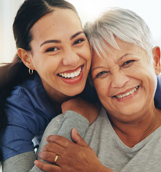 Two women smiling after replacing missing teeth in Alexandria