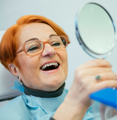 Dental patient admiring her smile in a mirror