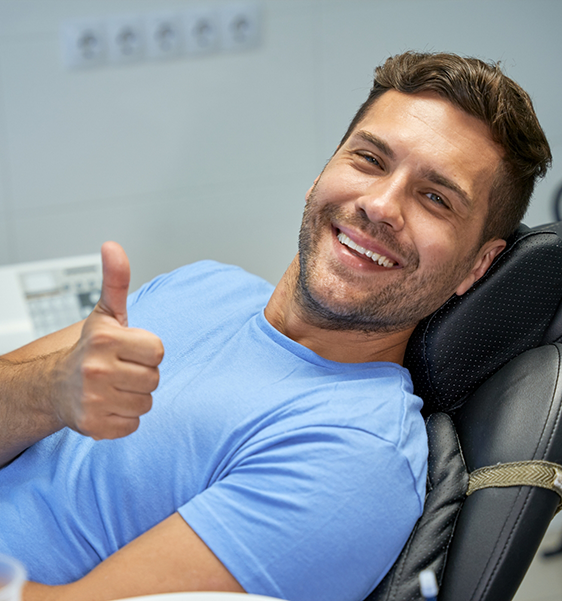 Smiling man giving a thumbs up in the dental chair