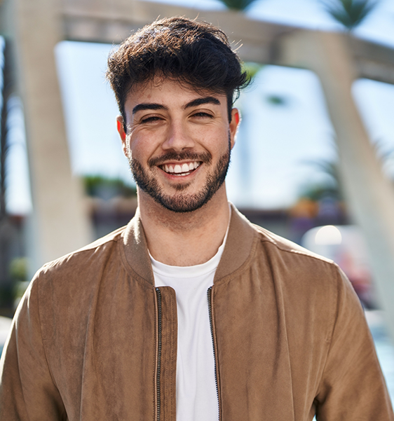 Young man smiling in a brown jacket