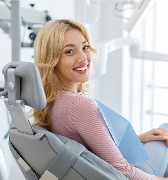 Woman smiling in the dental chair after receiving dental services in Alexandria