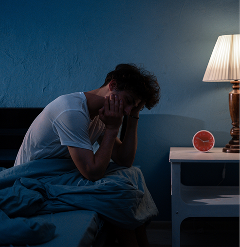 Frustrated man sitting on the edge of his bed