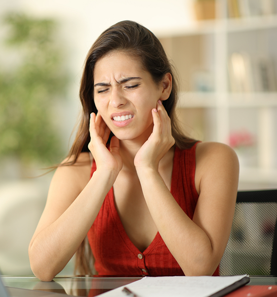 Woman holding the sides of her jaw in pain